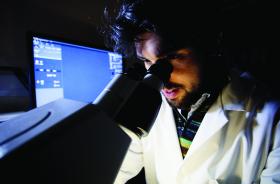 A student looking down a microscope